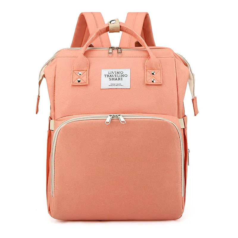 Peach-colored backpack with gold accents on a white background
