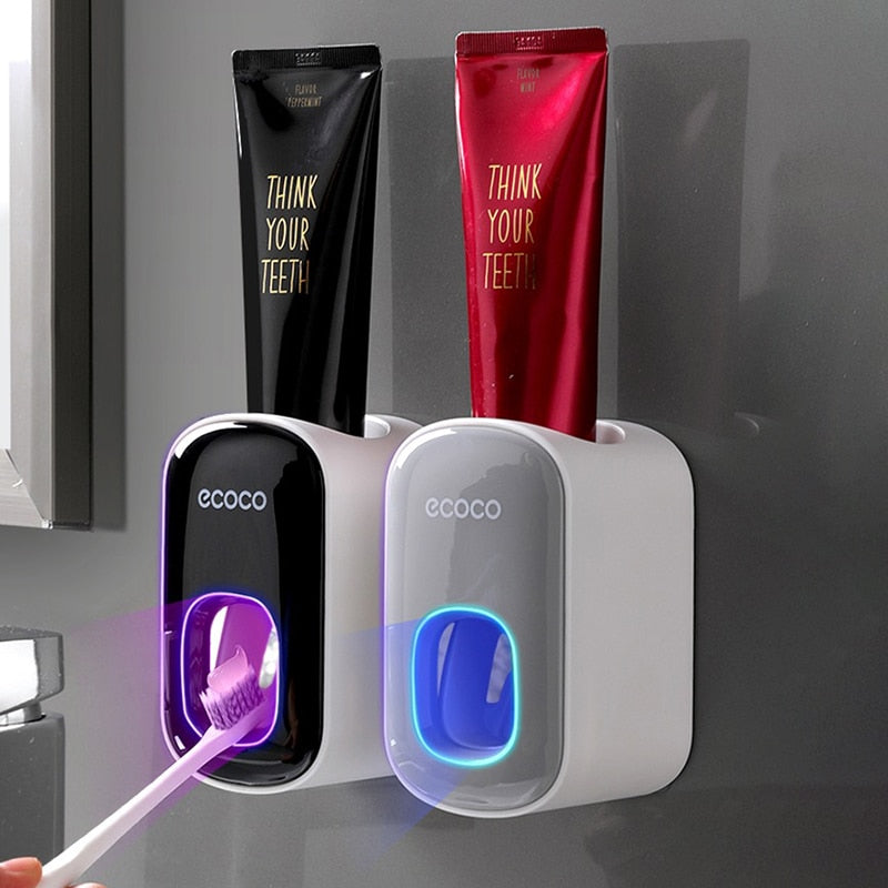 Wall-mounted toothbrush holder with toothpaste dispensers labeled 'ecoco' on a gray wall.